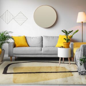 Shag rug with creamy white, yellow, and black abstract geometric patterns in a bright living room.