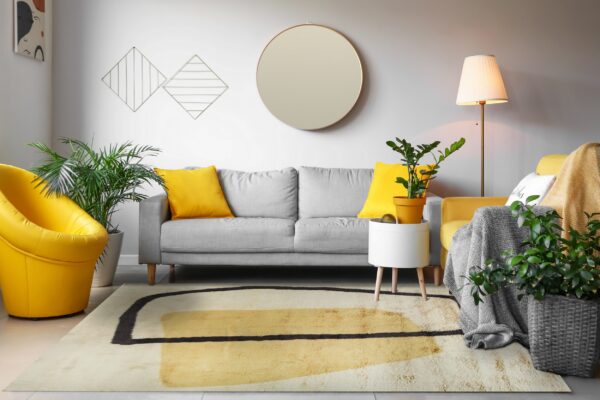 Shag rug with creamy white, yellow, and black abstract geometric patterns in a bright living room.