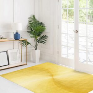 A rectangular yellow rug with a subtle radial gradient pattern rests on white flooring in a bright room.