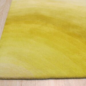 A plush yellow rug with a subtle ombre pattern rests on pale wood plank flooring.