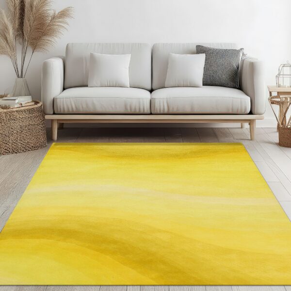 Abstract yellow and gold shaded rug on light flooring under a minimal white sofa.
