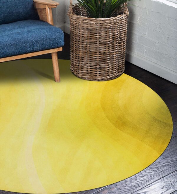 Bright yellow circular rug on dark wood, next to a blue chair and woven basket.