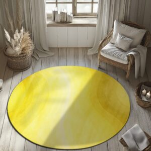Circular yellow rug with abstract gradient bands sits on light wood planks next to a rattan chair.