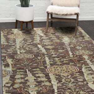 A distressed brown and beige area rug anchors a room with dark wood floors and a fur-covered chair.