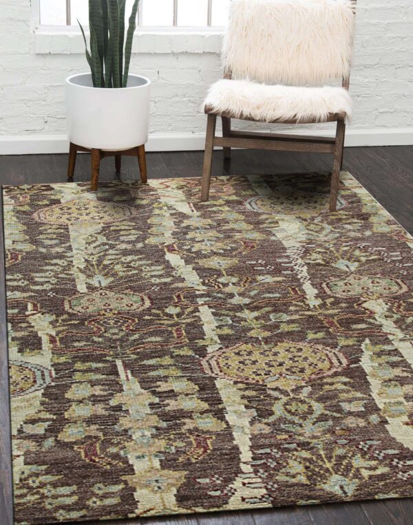 A distressed brown and beige area rug anchors a room with dark wood floors and a fur-covered chair.