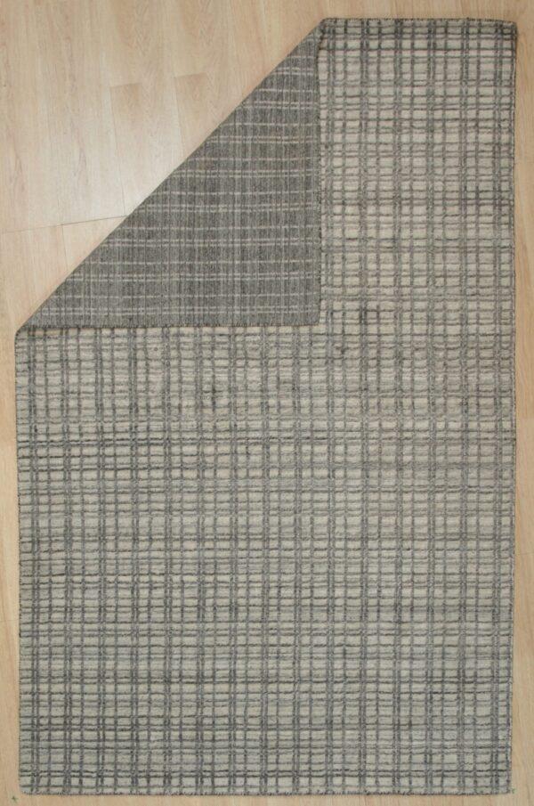 Light gray rug with a raised dark gray grid pattern rests on blonde wood flooring.