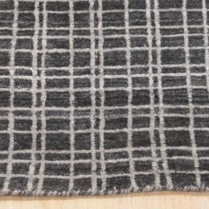 A dark mottled gray rug featuring a light gray windowpane check pattern rests on wood flooring.