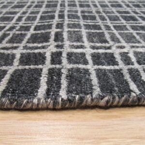 Textured gray rug with a light gray grid pattern shown closely on a light brown wooden surface.
