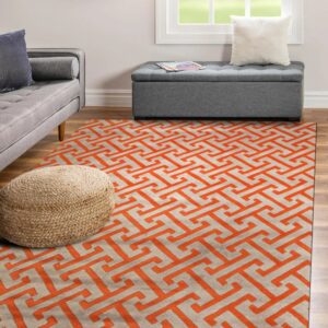 Orange and light gray high-pile rug with a geometric fret pattern anchors a room with a gray sofa.