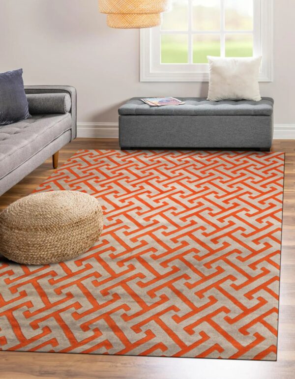 Orange and light gray high-pile rug with a geometric fret pattern anchors a room with a gray sofa.