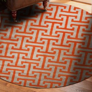 Circular rug featuring an orange fret pattern on a light gray background, beneath a studded brown chair leg.