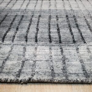 Textured, high-pile gray and white rug featuring a dark striped grid pattern over light wood flooring.