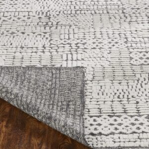 White rug with a high-low gray pattern lifted to show the woven backing and dark wood floor.