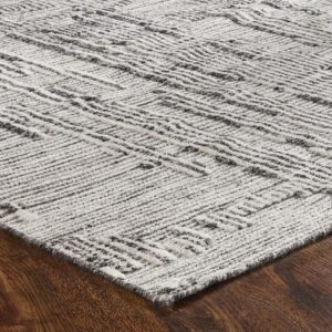 Textured gray and off-white rug with an abstract linear pattern rests on dark brown wood flooring.