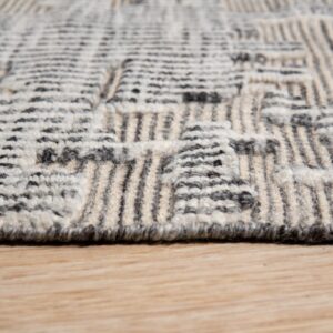 Textured cream and dark gray rug with a dimensional geometric pattern resting on light wood floor.