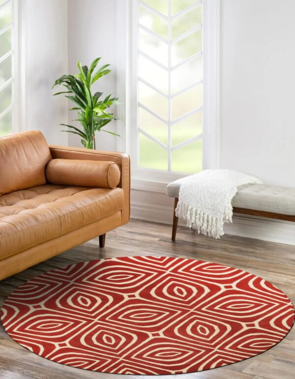 Round red rug with a cream abstract diamond pattern anchors a bright room with leather seating.