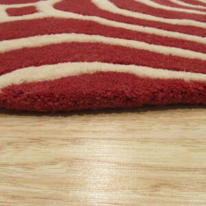 Close-up of a high-pile rug featuring thick red and cream wavy stripes on a glossy light wood floor.