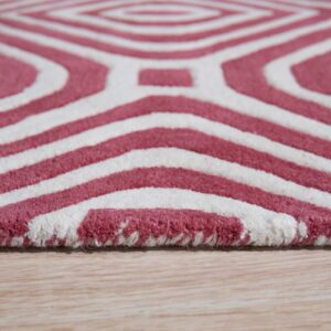 A thick, rose red and white rug featuring a geometric diamond pattern on light wood flooring.