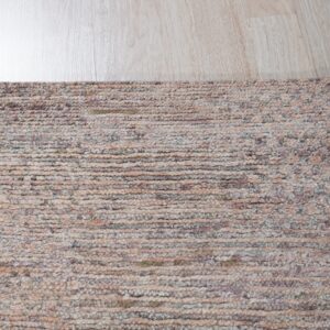 Muted multicolored chunky loop rug texture close-up on light blonde wood plank flooring.