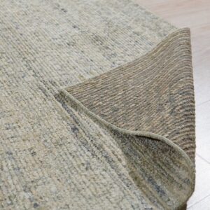Textured light beige rug partially rolled back on light wood flooring, revealing its woven brown underside.
