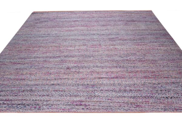 Low-pile rug displaying variegated horizontal stripes blending pink, dusty blue, and beige against a white background.