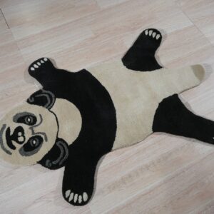 A shaped black, cream, and gray panda rug rests on light wood-look flooring.