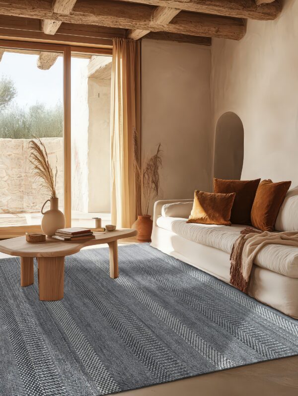 A gray and white textured chevron rug anchors a rustic living room with a white sofa and wood beams.