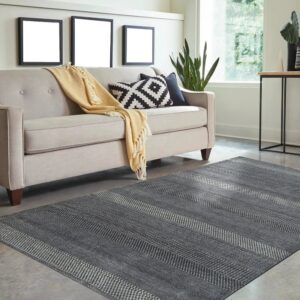 Gray rug featuring horizontal stripes of alternating geometric patterns anchors a light beige sofa.