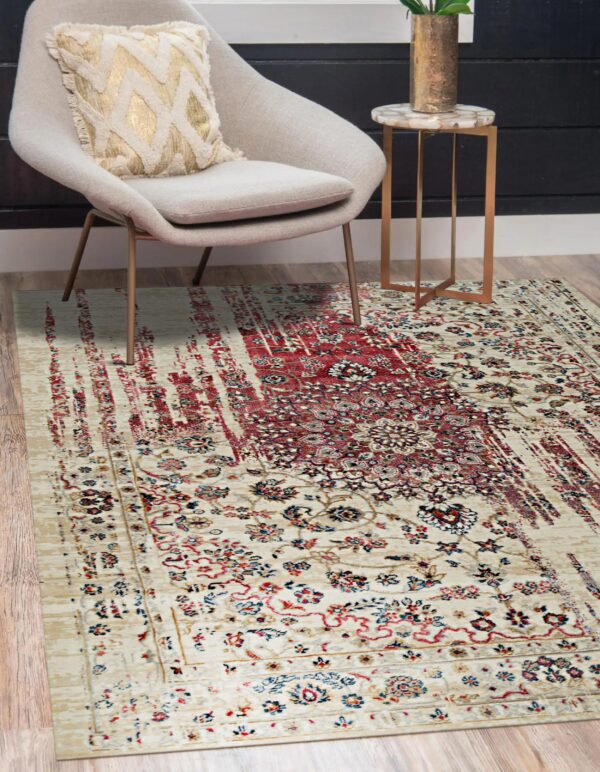 Cream and red traditional rug with a distressed stripe pattern placed beneath a modern gray chair.