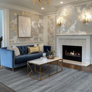 Gray rug with alternating chevron and striped bands defines a lavish living room space with a blue velvet sofa.