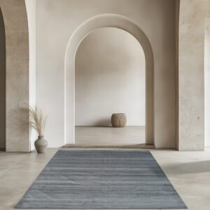 Gray runner rug with subtle horizontal texture stripes on light stone floors in an architectural arched hallway.