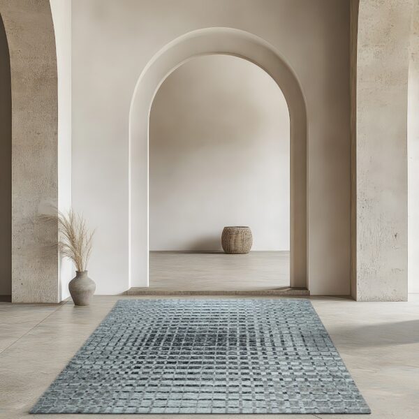 Distressed blue and gray runner rug with a checkered pattern in a neutral arched hallway with concrete floors.