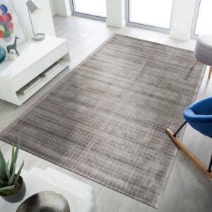 Low-pile gray and taupe rug featuring a linear abstract pattern in a bright living space.