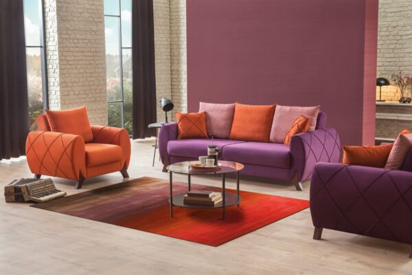 Red and brown gradient rug on light floors between purple and orange modern living room furniture.