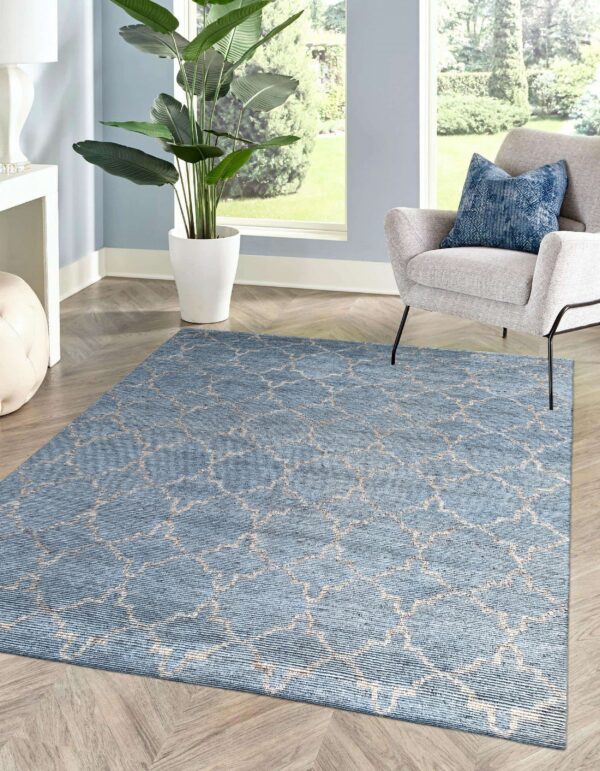Blue rug with light beige geometric lattice pattern on light wood herringbone flooring.