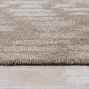 A textured beige rug with subtle abstract striping lies on pale wood plank flooring.