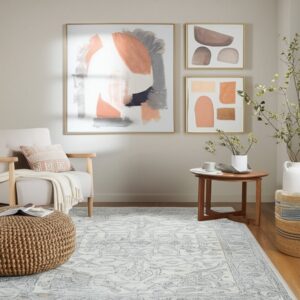 Cream and blue-gray traditional rug in a neutral living room with wood floors and modern art.