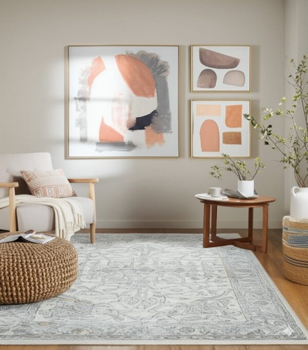 Cream and blue-gray traditional rug in a neutral living room with wood floors and modern art.