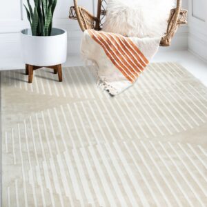 Beige and ivory striped rug placed on white flooring under a wicker hanging chair and plant.