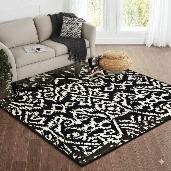 Glossy black and white abstract rug placed under a neutral sofa on brown plank flooring.