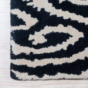 High-pile rug features black and cream wavy stripes placed over light wood flooring.
