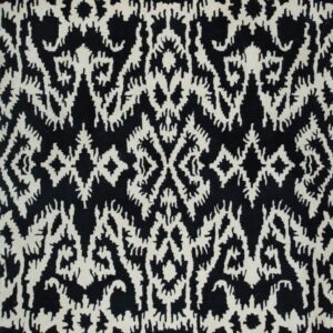 Close-up showing a high-pile black rug with an intricate off-white tribal pattern.