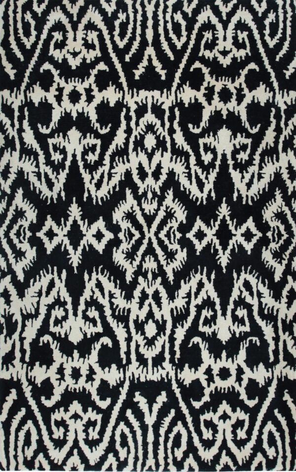 Close-up showing a high-pile black rug with an intricate off-white tribal pattern.