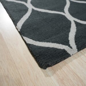 Close-up of a textured dark gray rug with a light ogee pattern on natural wood flooring.