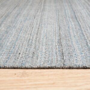 Textured gray rug with subtle blue vertical stripes rests on light wooden flooring.