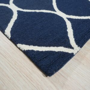 Textured navy rug with a white scalloped pattern sits on light blonde wood flooring.