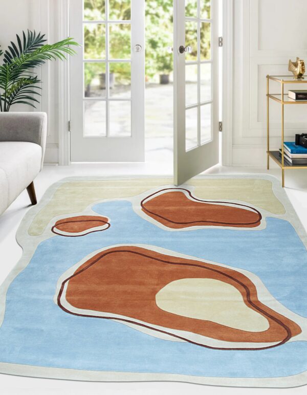 An abstract rug with blue, cream, and terracotta organic shapes lies on a white floor near french doors.