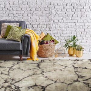 Light-colored rug with a dark crackle pattern anchors a gray sofa against a textured white brick wall.