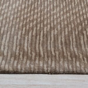 Textured beige rug with irregular vertical stripe patterns in contrasting dark and light brown tones on wood floor.
