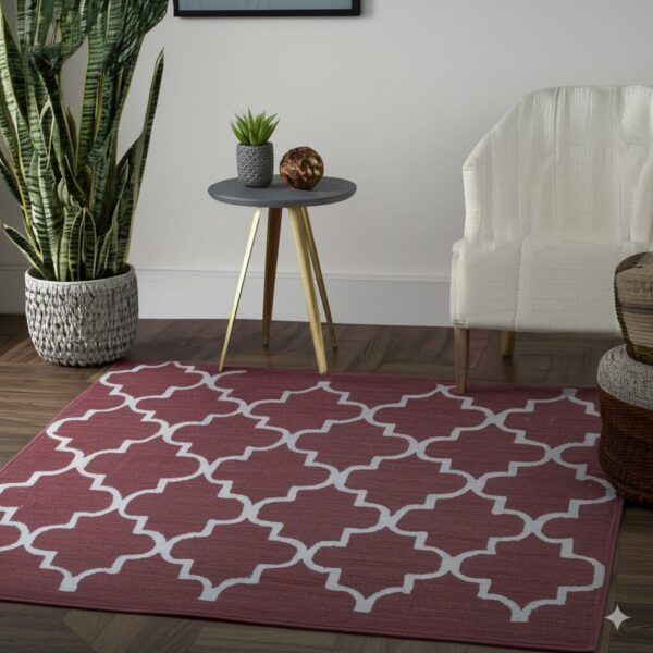 Burgundy and white trellis rug displayed on dark wood floors next to a white armchair and large potted plant.